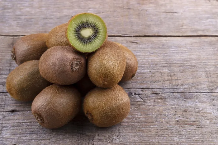 Framed Print : Pile of fresh kiwi on an old wooden board