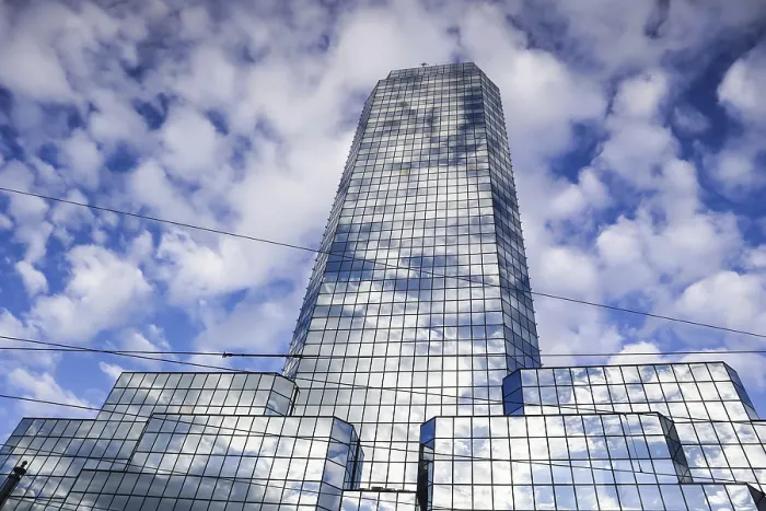Framed Print : Poland, February 2019: A modern reflective office skyscraper against a blue sky with white clouds Framed Print : Poland, February 2019: A modern reflective office skyscraper against a blue sky with white clouds