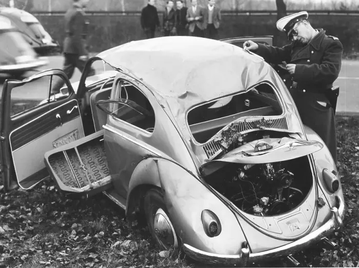 Framed Print : Police officer inspects VW beetle with total damage Framed Print : Police officer inspects VW beetle with total damage