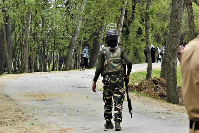 Framed Print : Policeman running Kashmiri students protesting
