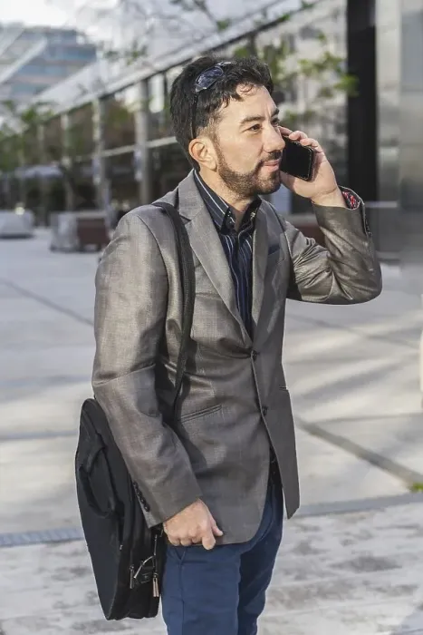 Framed Print : Portrait of a businessman talking on the cell phone outside his office