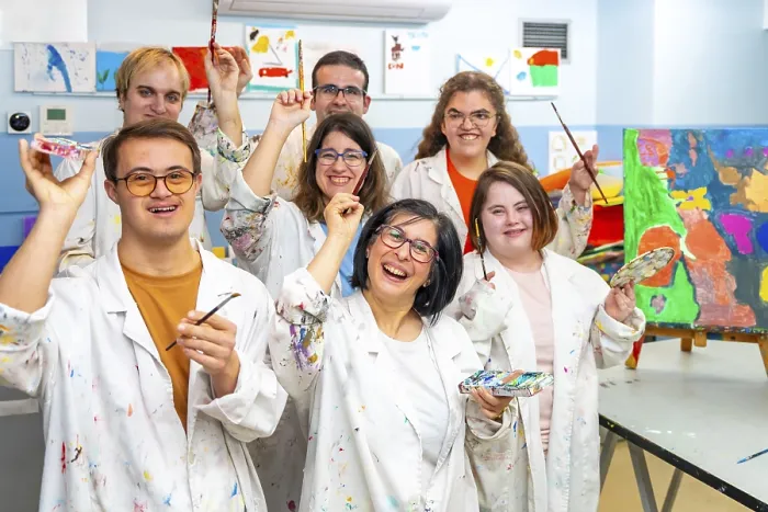 Framed Print : Portrait of a group of happy disabled people with dirty coats in a painting class