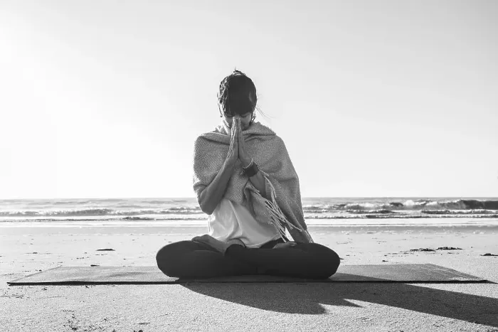 Framed Print : Portrait of a woman clasping hands while holding a japa mala at the beach
