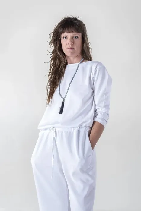 Framed Print : Portrait of a woman dressed in white yoga clothes over white background wearing a japa mala while looking at camera