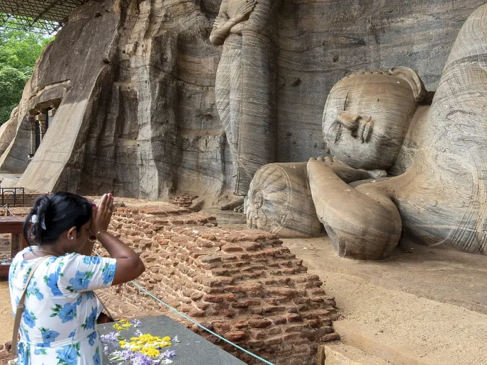 Framed Print : Praying woman in front of a reclining Buddha statue