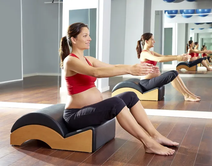 Framed Print : Pregnant woman pilates exercise with spine wave corrector