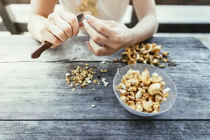 Framed Print : Preparing chanterelle mushrooms on an old rustic wooden table