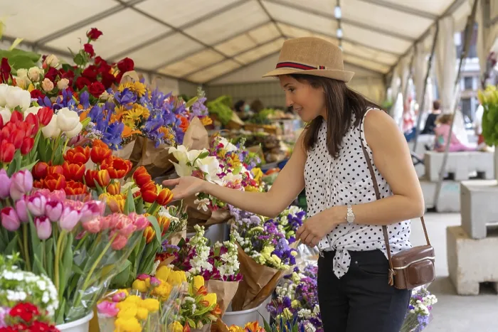 Framed Print : A pretty tourist with a photo camera visiting a flower market