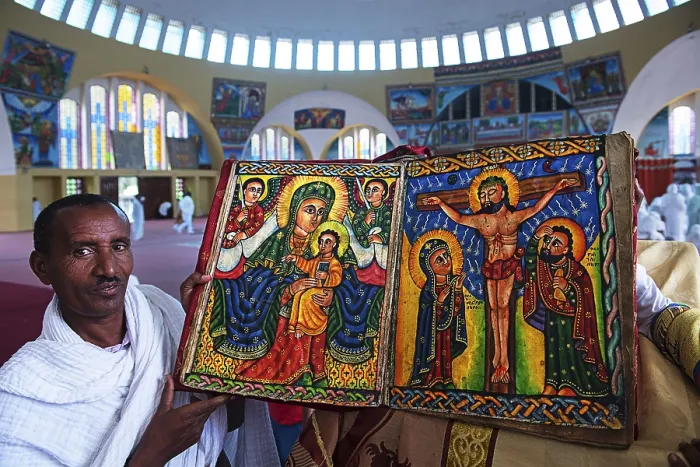 Framed Print : Priest shows hand-painted Bible with Mary and Jesus and Crucifixion Jesus