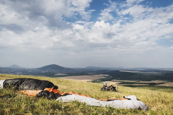 Framed Print : A professional paraglider in full gear and a helmet lies Framed Print : A professional paraglider in full gear and a helmet lies