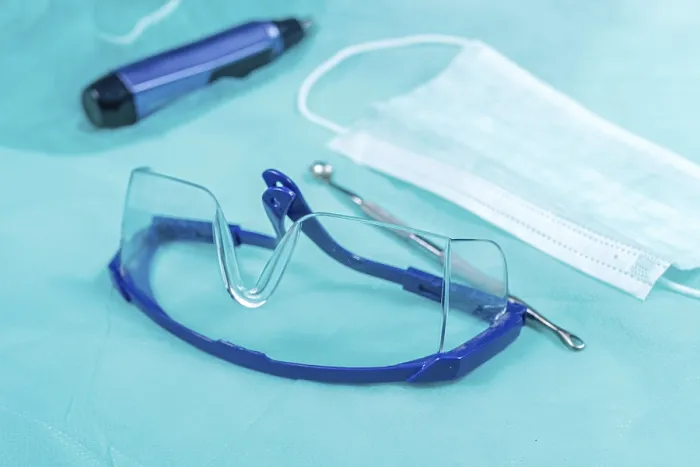 Framed Print : Protective eyewear alongside mask and medical tools on a blue surface