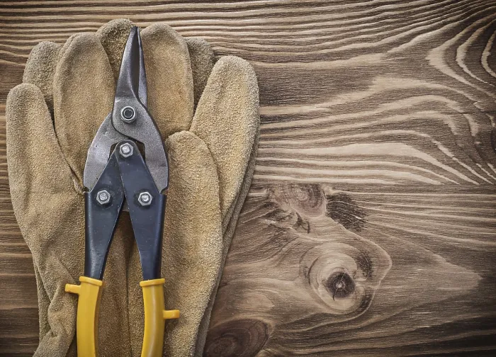Framed Print : Protective gloves metal tin snips on wooden board construction concept