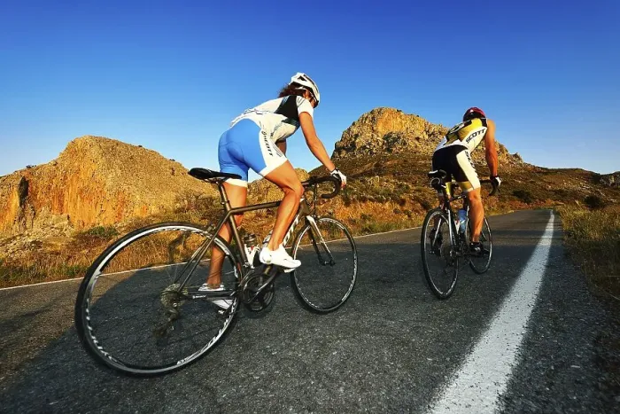 Framed Print : Two racing cyclists cycle uphill on the road
