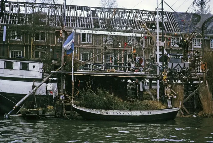 Framed Print : Radio Baskerville sign on a canal boat next to a derelict building, Amsterdam 1973