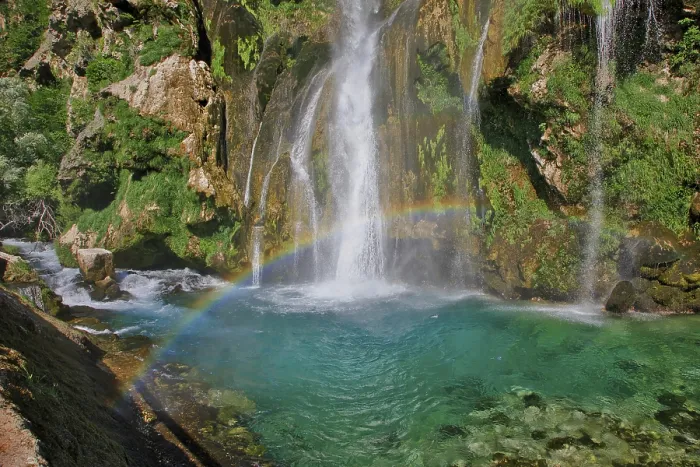 Framed Print : A rainbow stretches over a waterfall that flows into clear turquoise water Framed Print : A rainbow stretches over a waterfall that flows into clear turquoise water