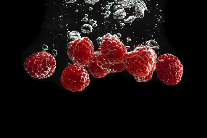 Framed Print : Raspberries fall into water, black background Framed Print : Raspberries fall into water, black background