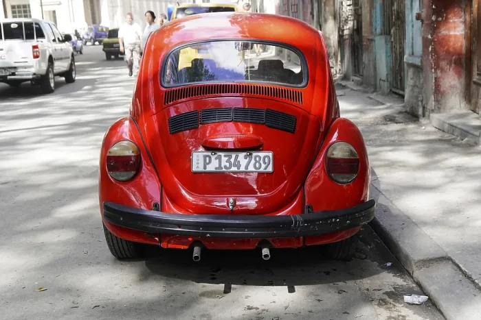 Framed Print : The rear view of a vintage red VW Beetle car on an urban road