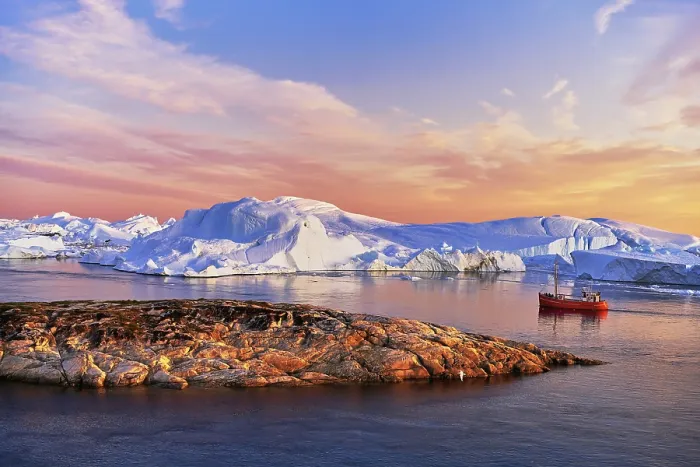 Framed Print : Red boat with tourists in front of icebergs in evening light Framed Print : Red boat with tourists in front of icebergs in evening light