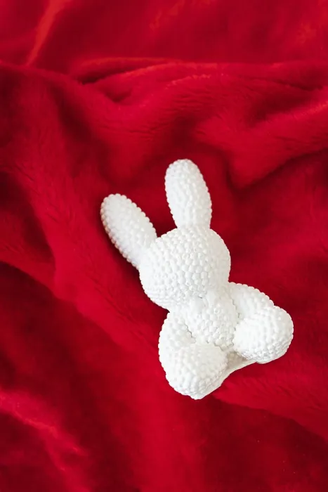 Framed Print : A red ceramic white rabbit lies on a red background Framed Print : A red ceramic white rabbit lies on a red background
