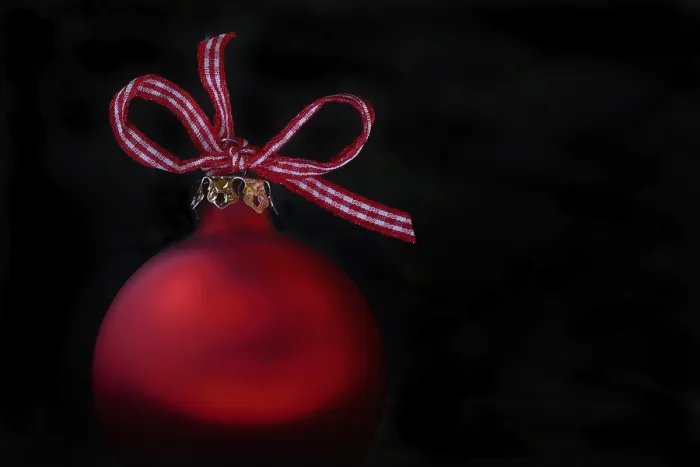 Framed Print : Red Christmas tree bauble with bow on a black background
