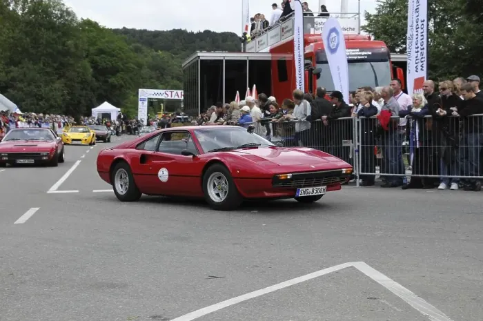 Framed Print : A red classic car at a motorsport event in front of an enthusiastic audience