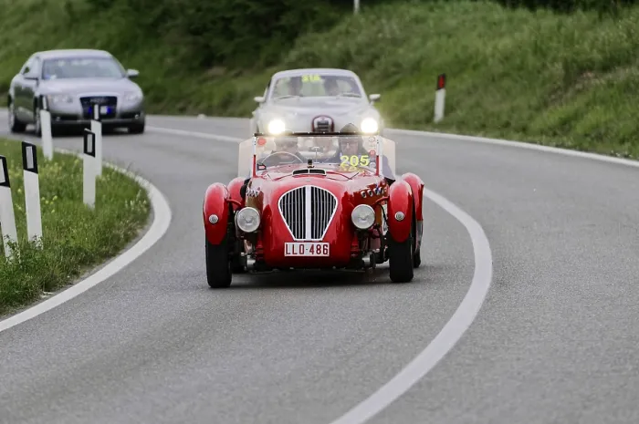 Framed Print : A red classic car on a winding road during a rally Framed Print : A red classic car on a winding road during a rally