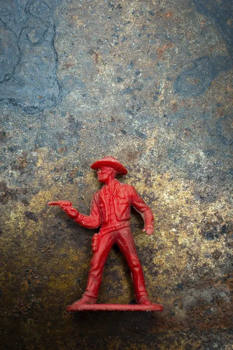 Framed Print : A red cowboy figure is positioned confidently with a raised finger