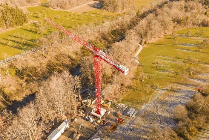 Framed Print : Red crane on construction site in autumn landscape with forests and meadows from a bird's eye view