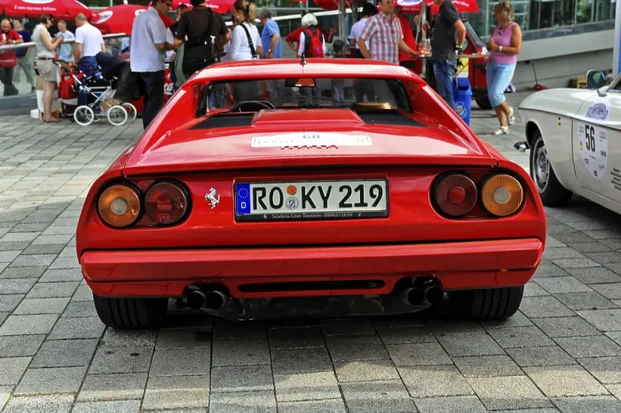 Framed Print : Red Ferrari sports car seen from behind among other classic cars
