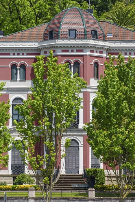 Framed Print : A red historic building with a dome surrounded by green trees