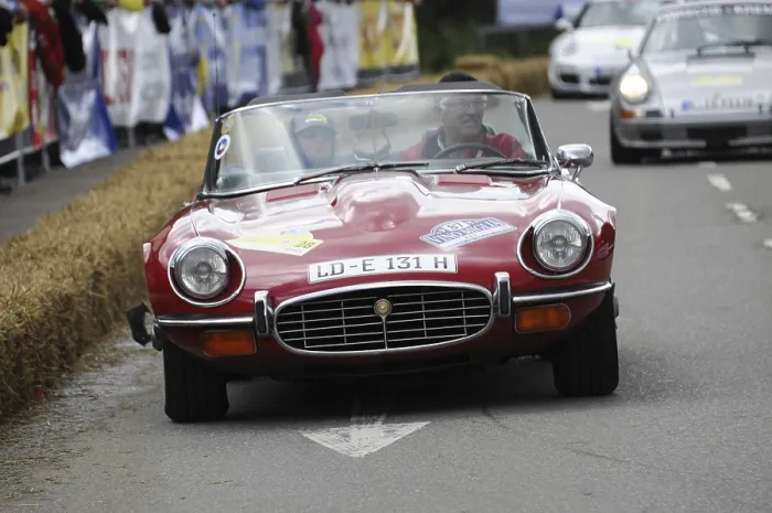 Framed Print : A red Jaguar E-Type convertible drives on a closed-off race track