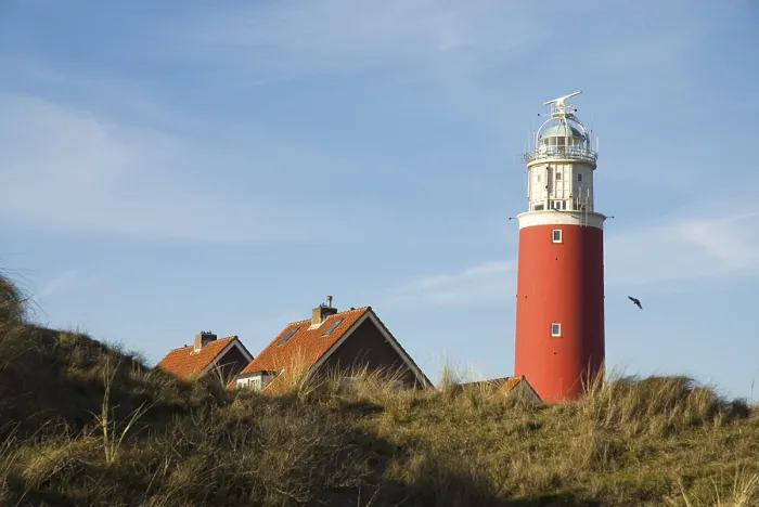 Framed Print : Red lighthouse with small village