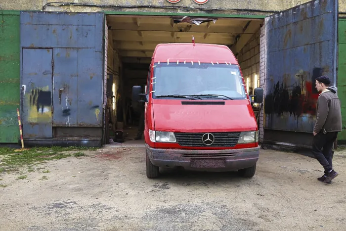 Framed Print : Red Mercedes van in front of a garage with a person nearby