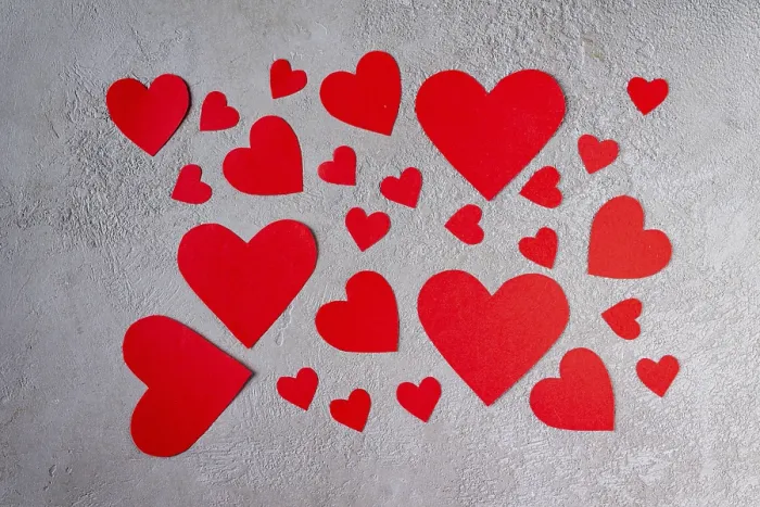 Framed Print : Red paper hearts scattered over gray plaster
