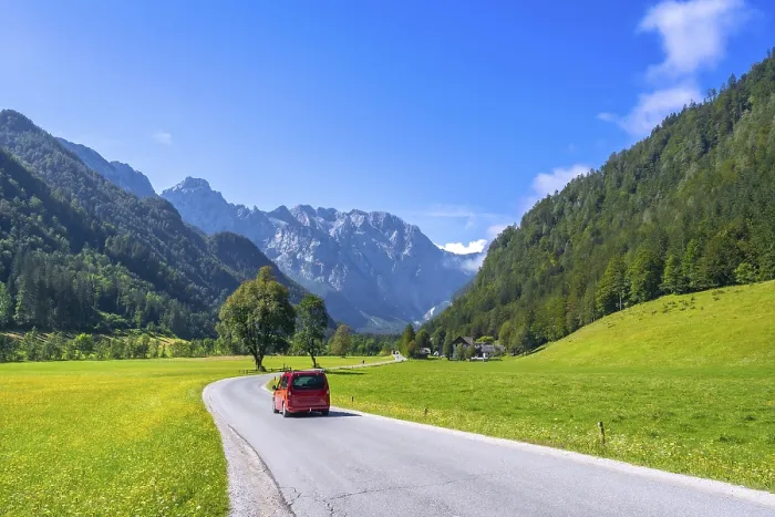 Framed Print : Red van driving along a winding road in the picturesque logarska dolina valley