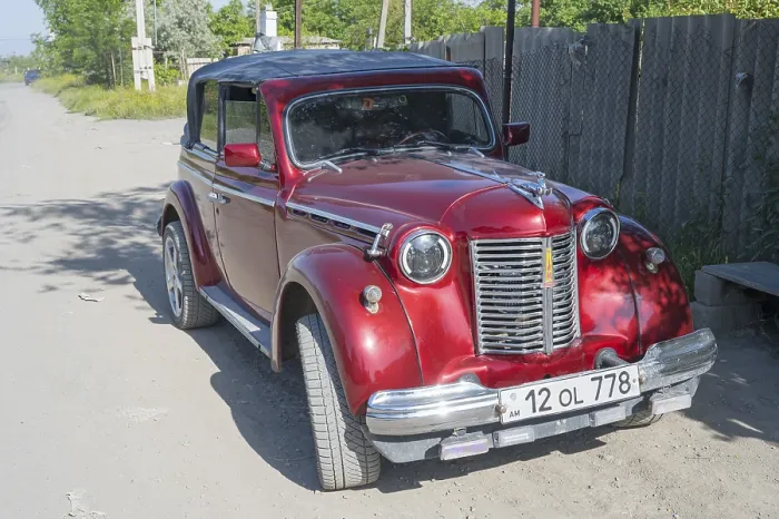 Framed Print : Red vintage car parked on a dusty road in the sunshine