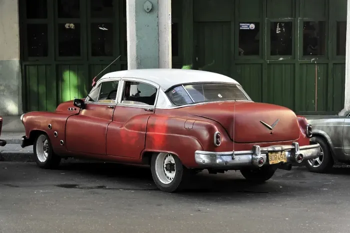 Framed Print : A red vintage car parked on a street corner in Cuba