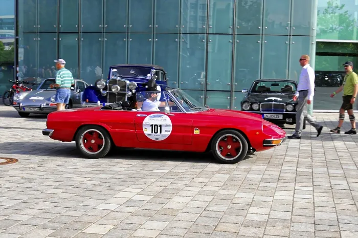 Framed Print : A red vintage convertible in front of a modern glass building at a car exhibition