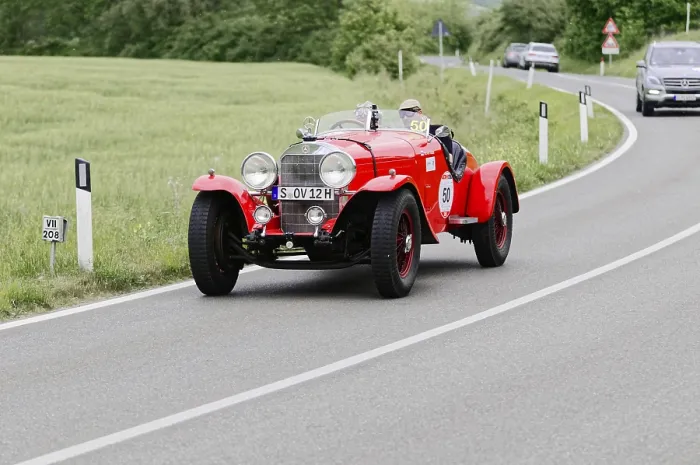 Framed Print : A red vintage racing car drives on a country road