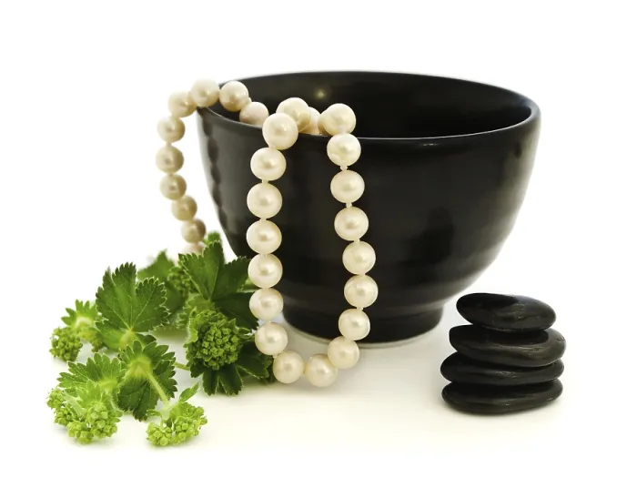 Framed Print : Relax theme with pearl beads, Zen stones and green herb over white background Framed Print : Relax theme with pearl beads, Zen stones and green herb over white background