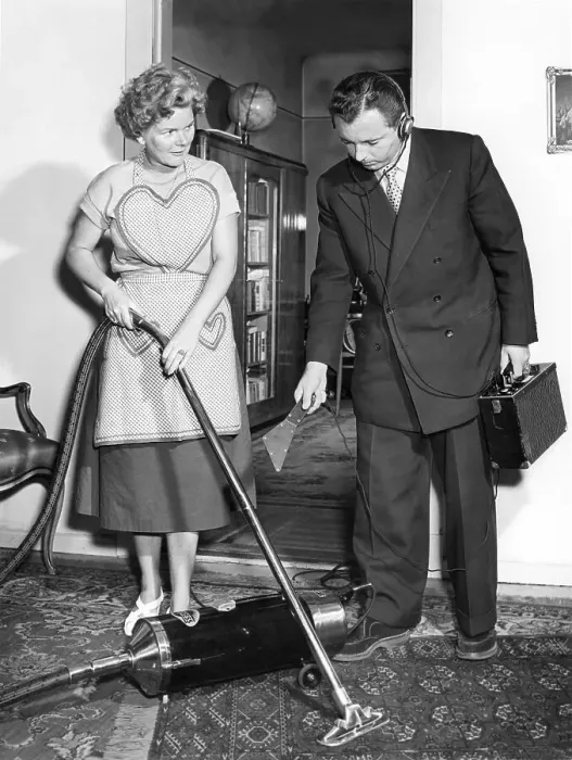 Framed Print : Representative and housewife with vacuum cleaner