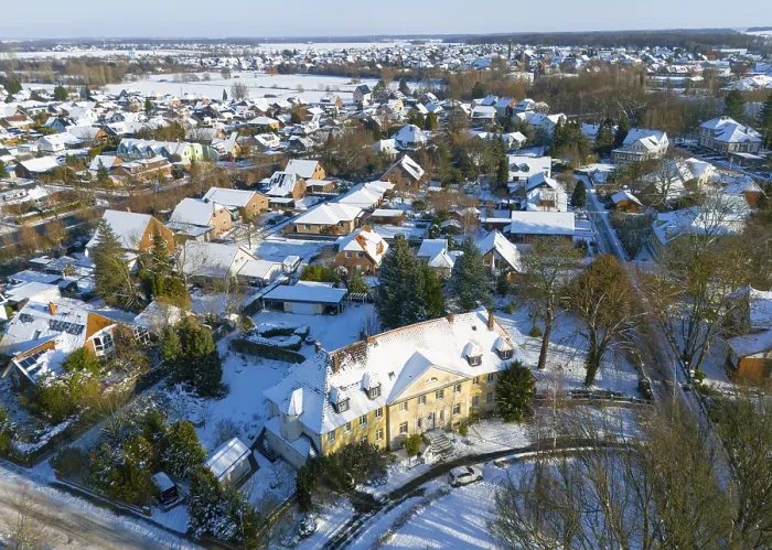 Framed Print : Residential area in winter with snow-covered classic buildings and trees