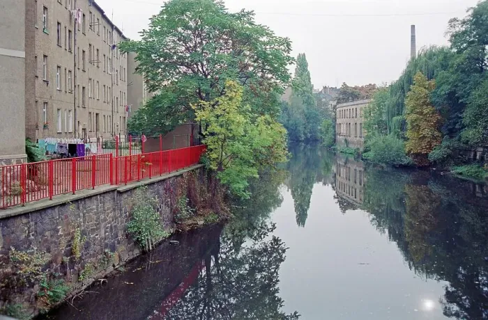 Framed Print : Residential buildings and factory by the river in