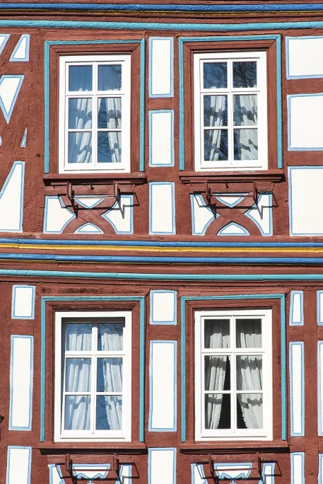 Framed Print : A restored and colourfully painted half-timbered facade with windows