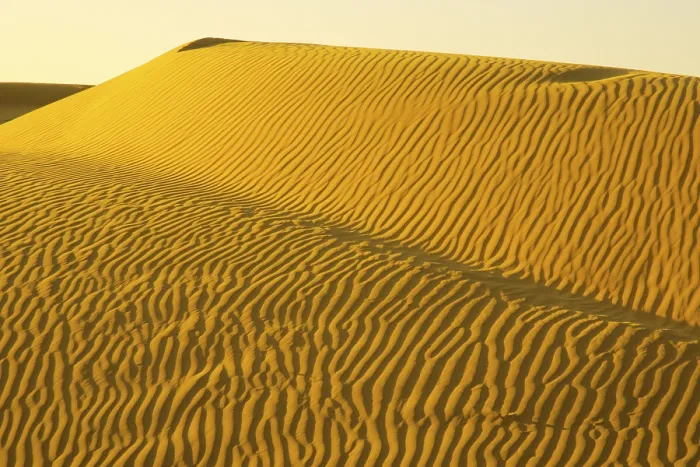 Framed Print : Ripple design on golden sand dunes due to wind with highlight and shadow play at Sam