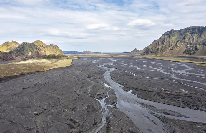 Framed Print : River with fanned out branches through black lava sand