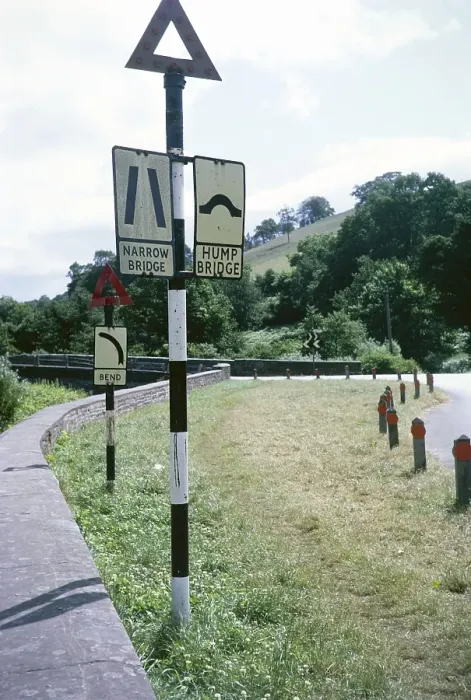Framed Print : Road signs for a narrow humpback bridge on a bend, Skenfrith Bridge, Monmouthshire, Wales, UK 1967