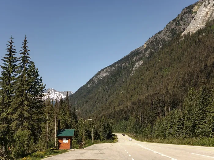 Framed Print : Empty road stretches through a forest with towering mountains on the Trans Canada Highway in British Columbia