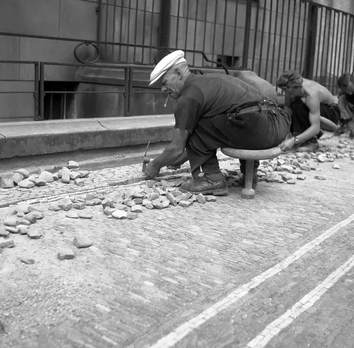 Framed Print : Road workers paving a road with natural stones