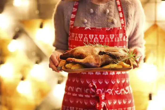 Framed Print : Roast duck and potato on wooden plate in womans hands Framed Print : Roast duck and potato on wooden plate in womans hands